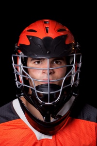 Male lacrosse player with helmet on.