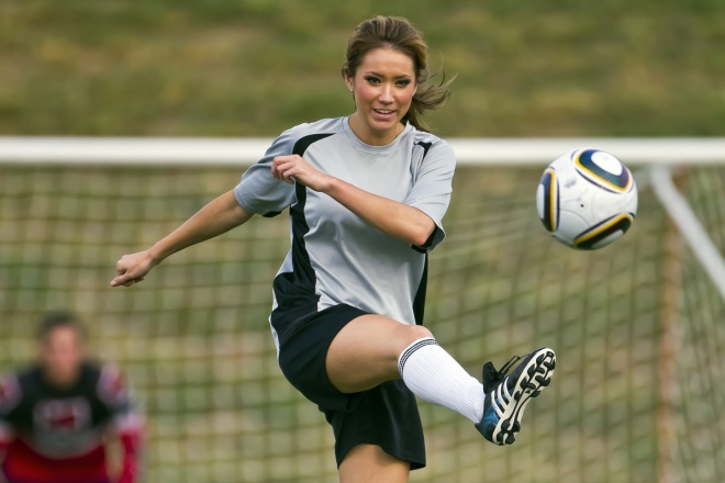 Female soccer player kicks a ball