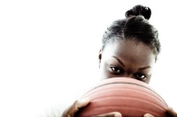 Female basketball player looking over a ball