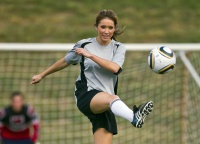 Female soccer player kicks a ball