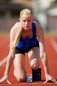 Female track sprinter in blocks.