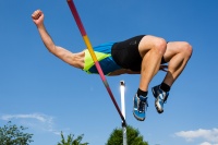 Male high jumper clears the bar.