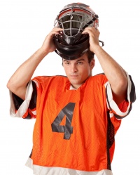 Male lacrosse player suiting up.