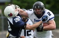 Football player stiff arms an opponent.
