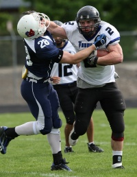 Runningback stiffarms a defender