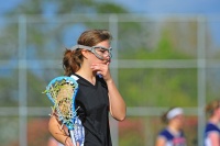 Female lacrosse player thinking.